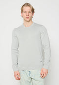 Hellgrauer Strickpullover mit langen Ärmeln und Rundhalsausschnitt, ausgestattet mit einer strukturierten Oberfläche und einem kleinen schwarzen Logo am Saum.