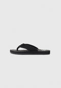 Schwarze Flip-Flop-Sandalen mit strukturiertem Fußbett und breitem Stoffzehenriemen, seitlich gegen einen schlichten hellen Hintergrund abgebildet.