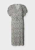 Schwarz-weiß gemustertes knielanges Kleid mit kurzen Ärmeln und einem angesammelten Taillengürtel auf einem einfarbigen Hintergrund.