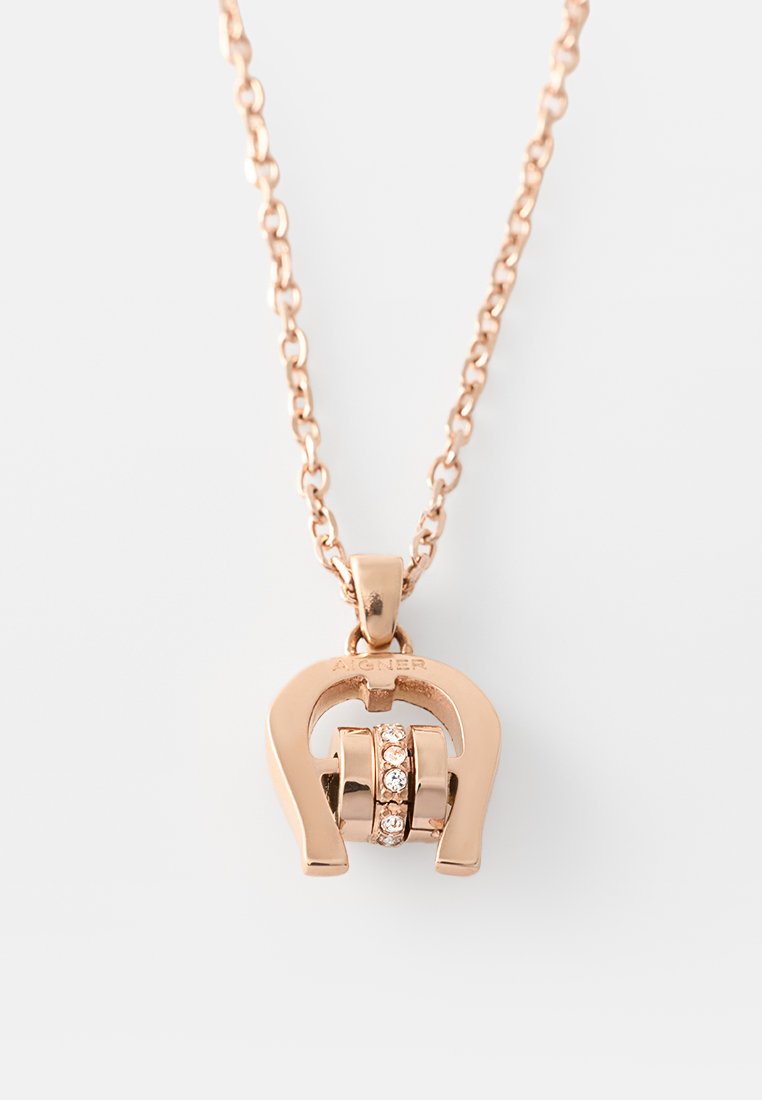 Roségold-Halskette mit einem hufeisenförmigen Anhänger, der einen rotierenden Zylinder mit kleinen klaren Kristallen auf weißem Hintergrund ziert.