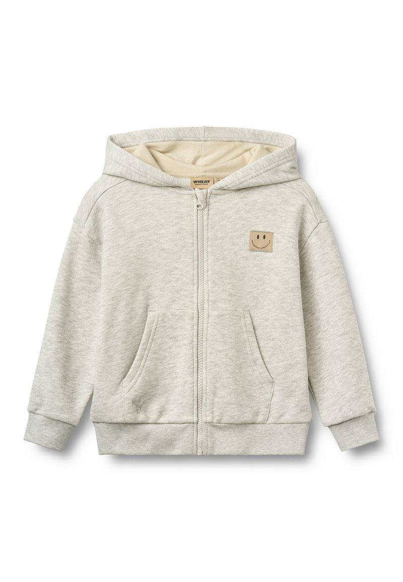 Hellgrauer Kapuzenpullover mit Reißverschluss, Fronttaschen und einem kleinen beigen Fleck mit einem Smiley auf der Brust.