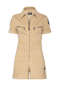 Beige Baumwoll-Overall mit kurzen Ärmeln, Reißverschluss vorne, zwei Brusttaschen und einer taillierten Taille. Mit einem schwarzen Patch auf dem linken Ärmel.