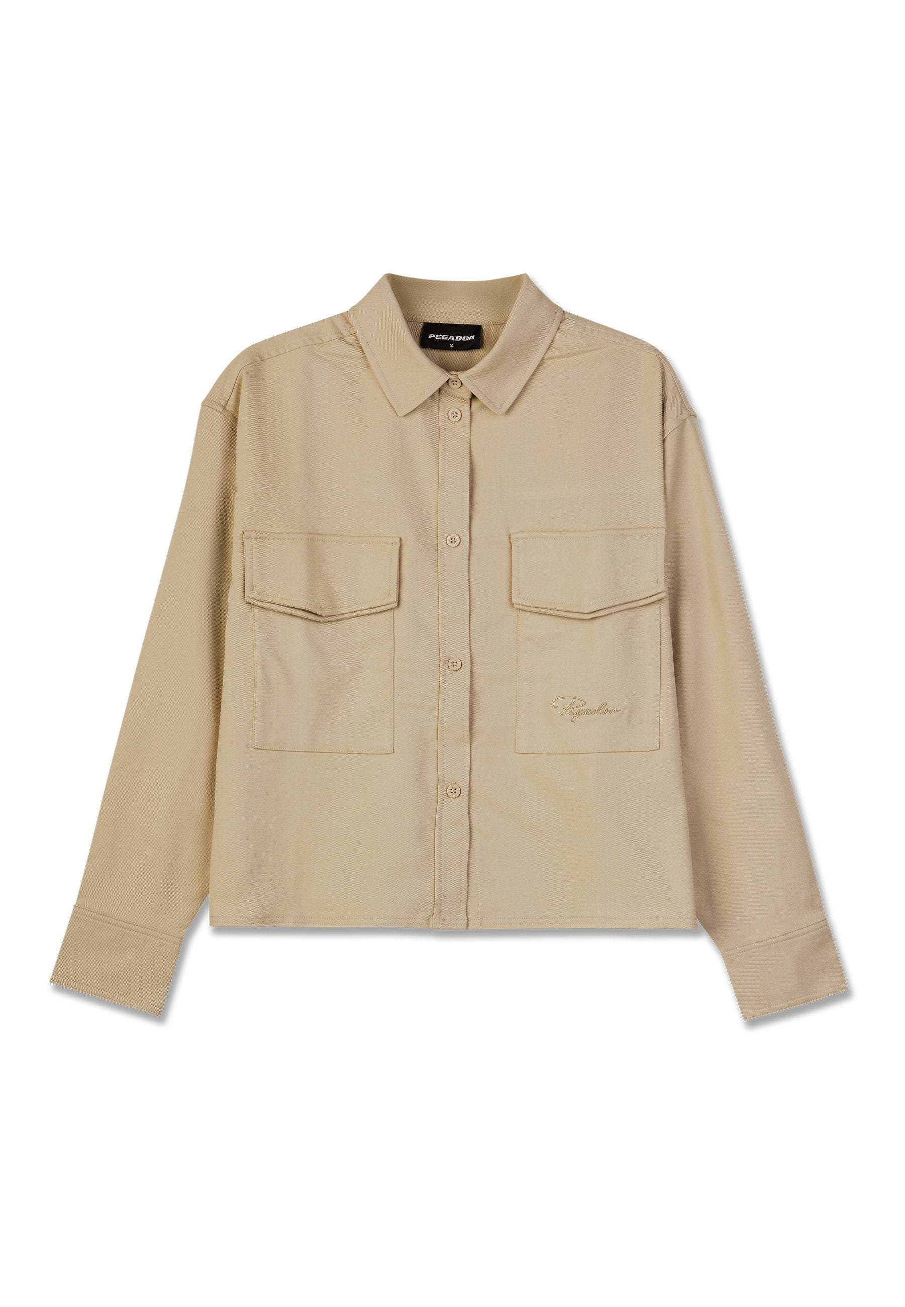 Beige Langarmshirt aus weichem Stoff, mit Knopfverschluss, zwei Brusttaschen und geradem Saum. Dezente Logo-Stickerei auf der Vorderseite.