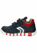 Marineblaue Sportschuhe mit roten Akzenten, zwei Klettverschlüssen, strukturiertem Material, weißer Sohle und silbernem Logo-Detail an der Seite.