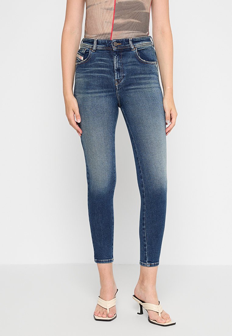 Schmale High-Waist-Jeans aus dunkelblauem Denim mit modischer Waschung. Verfügt über Fronttaschen, einen Knopfverschluss und eine elegante Passform.