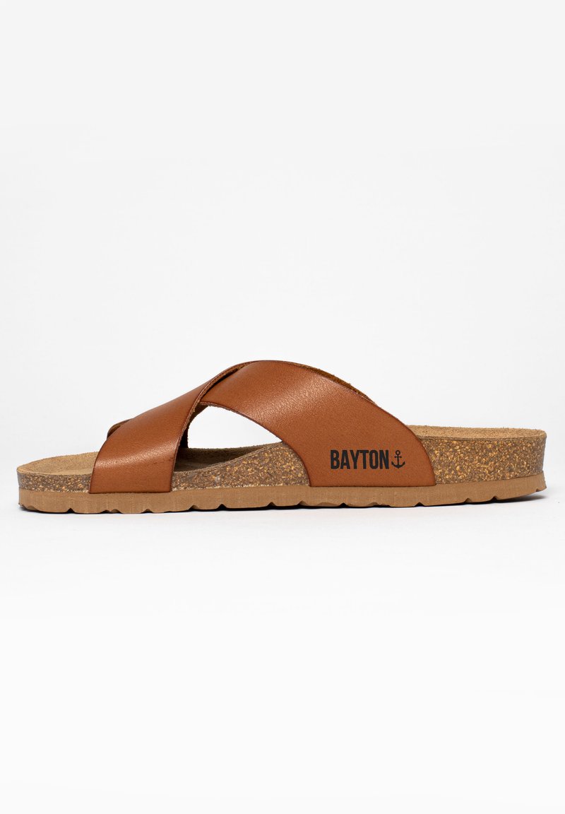 Braune Leder-Sandale mit überkreuzten Riemen, Kork-Mittelsohle und strukturiertem Gummi-Außensohle. Mit einem Logo an der Seite.