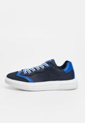 Dunkelblauer Sneaker mit weißer Sohle und blauen Akzenten, ausgestattet mit weiß-blauen gestreiften Schnürsenkeln auf einem schlichten hellgrauen Hintergrund.