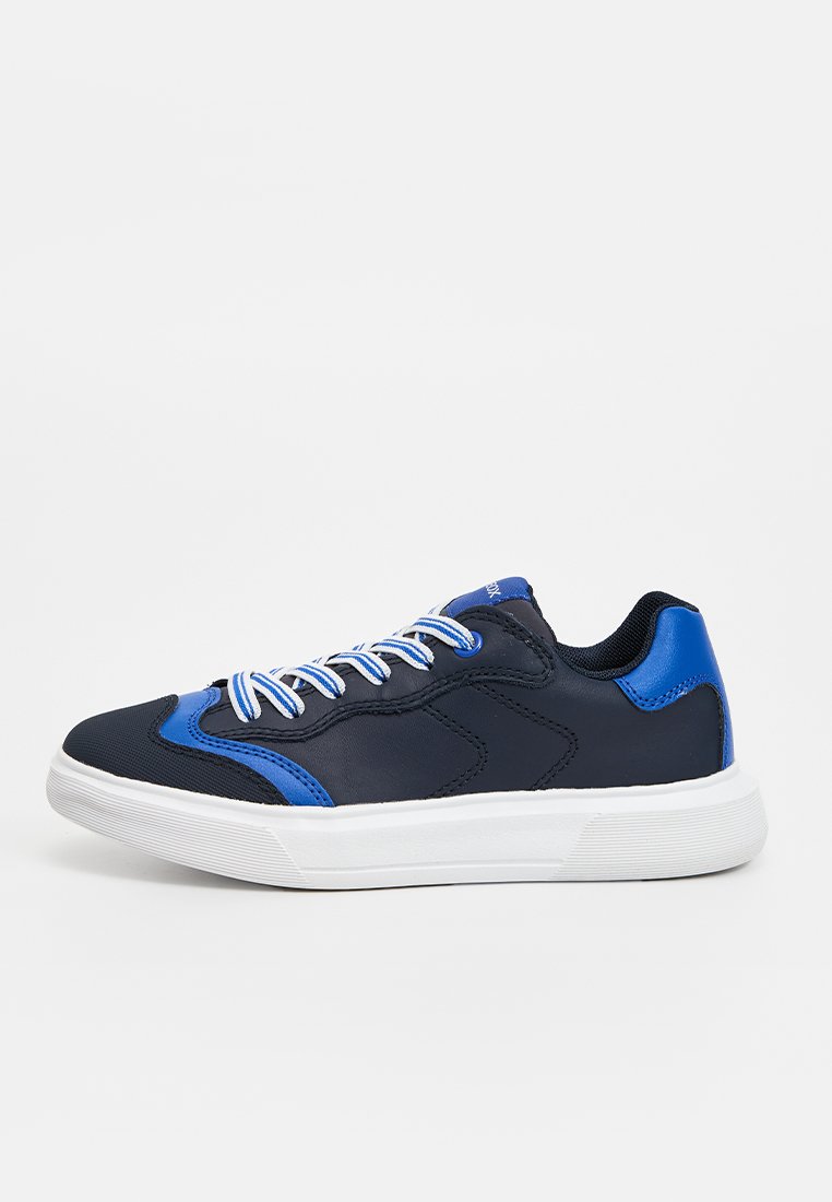 Dunkelblauer Sneaker mit weißer Sohle und blauen Akzenten, ausgestattet mit weiß-blauen gestreiften Schnürsenkeln auf einem schlichten hellgrauen Hintergrund.