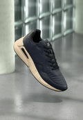 Marineblaue Sneaker mit strukturiertem Obermaterial, schwarzen Akzenten und einer beigen Sohle. Verfügt über ein Schnürdesign und sichtbare Air-Dämpfungsdetails.