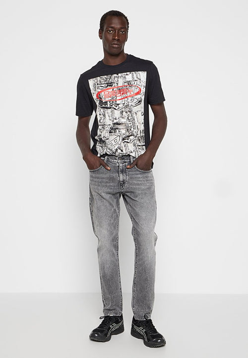 Schwarzes Grafik-T-Shirt mit einem großen weißen und roten Druck, kombiniert mit verwaschenen grauen Jeans und schwarzen Sneakern mit weißen Akzenten.