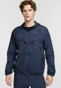 Marineblaue, leichte Jacke mit Kapuze, Reißverschluss vorne und reflektierenden Akzenten. Sie hat elastische Bündchen und ein glattes, wasserabweisendes Material.