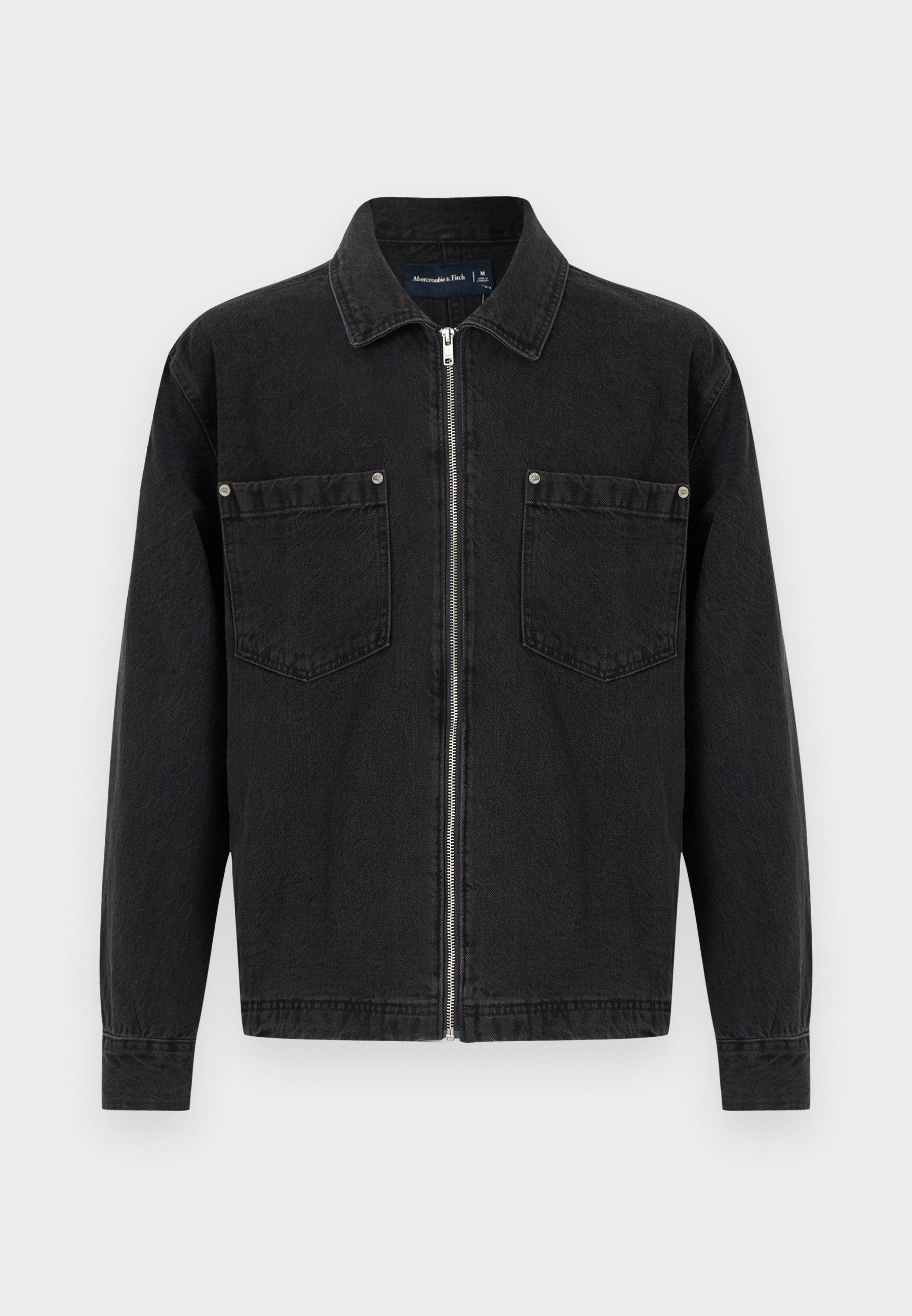 Schwarze Jeansjacke mit langen Ärmeln, durchgehendem Frontreißverschluss, zwei Brusttaschen mit Knopfdetails und einem klassischen Kragen.