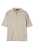 Beige Poloshirt mit kurzen Ärmeln und V-Ausschnitt, ausgestattet mit einem strukturierten Zickzack-Muster und einer kleinen Brusttasche. Hergestellt aus weichem Strickmaterial.