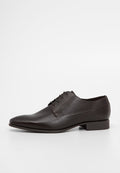 Braune Leder-Schuh mit glatter Textur, spitzer Nase und vier Ösen-Schnürung. Verfügt über einen niedrigen Absatz und ein sauberes, minimalistisches Design.