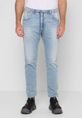 Mann trägt hellblaue Denim-Jogger-Jeans mit verstellbarem Bund und schwarze Sportschuhe und steht vor einem weißen Hintergrund.