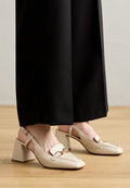 Beige Leder Slingback-Pumps mit quadratischer Zehenpartie und robustem Absatz. Mit einem goldfarbenen Doppelkreis-Akzent auf dem Vorderfuß.