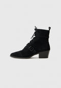 Schwarze Wildleder Stiefelette mit spitzer Zehenform, Schnürung an der Vorderseite, verstellbarem Riemen mit Schnalle und gestapeltem Absatz. Glatte Textur mit matter Oberfläche.