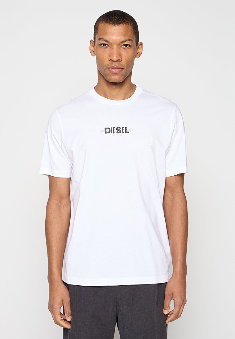 Weißes Baumwoll-T-Shirt mit Rundhalsausschnitt und kurzen Ärmeln, mit einem schwarzen "DIESEL"-Logo, das quer über die Brust gedruckt ist. Klassische Passform.
