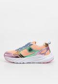 Klobiger Sneaker mit pfirsichfarbenem Stoff, metallisch rosa, grünen und goldenen Überzügen, blauen Schnürsenkeln, weißer Sohle und rosafarbenem Profil, in Seitenansicht gezeigt.