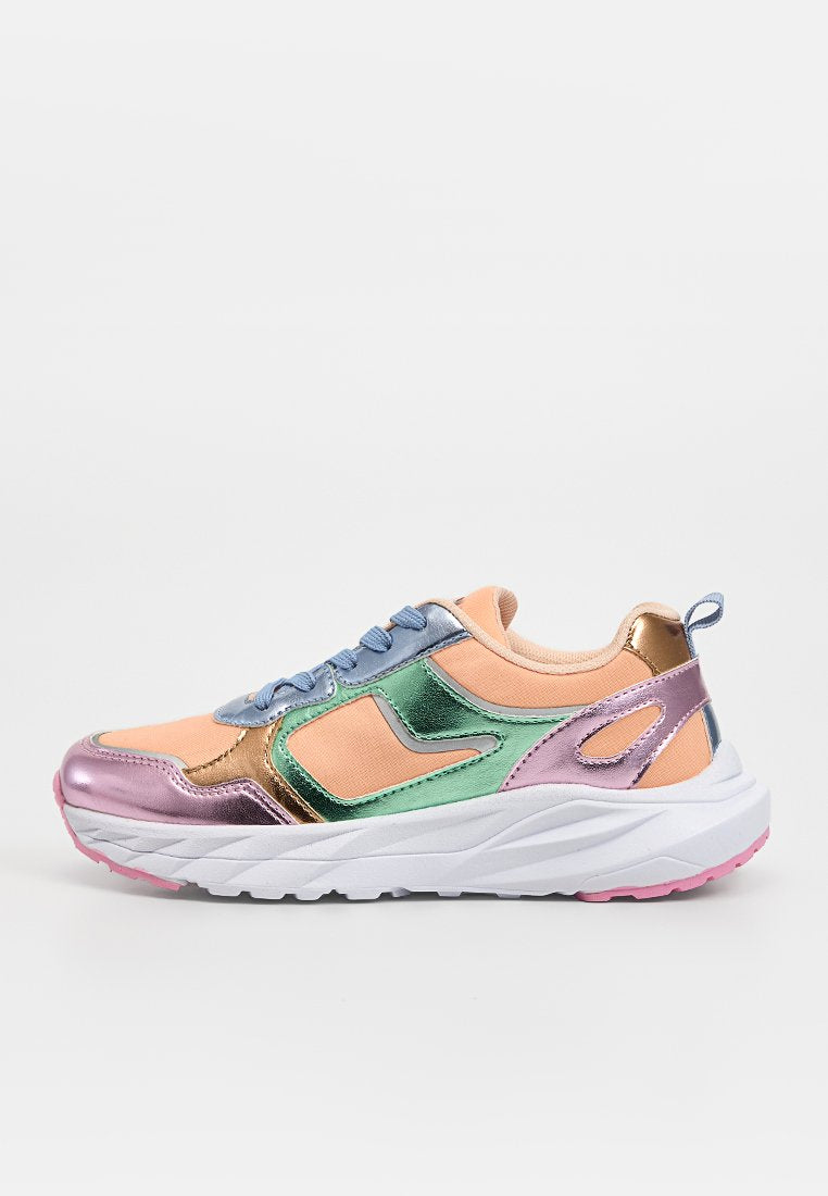 Klobiger Sneaker mit pfirsichfarbenem Stoff, metallisch rosa, grünen und goldenen Überzügen, blauen Schnürsenkeln, weißer Sohle und rosafarbenem Profil, in Seitenansicht gezeigt.