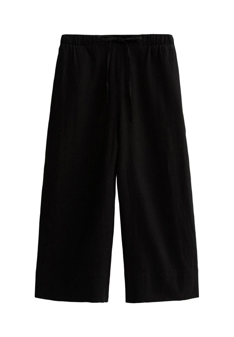 Schwarze weit geschnittene Hose aus leichtem Stoff, mit einem elastischen Bund und einem Kordelzug sowie einer glatten Textur.