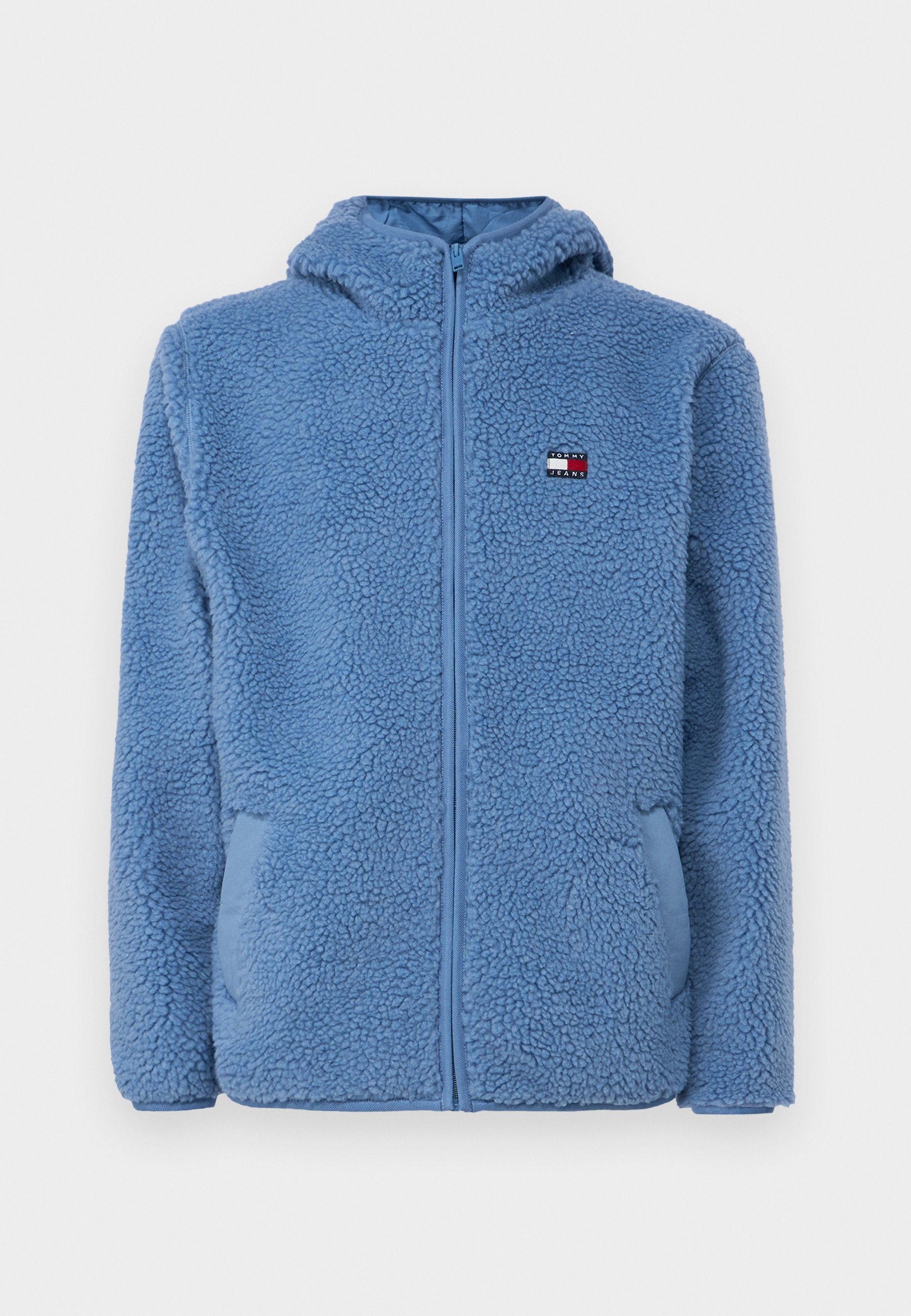 Helle blaue Fleecejacke mit Reißverschluss vorne, Kapuze und zwei Seitentaschen. Verfügt über ein kleines Logo-Patch auf der oberen linken Brust. Strukturiertes Finish.