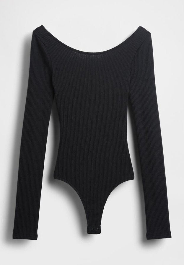 Schwarzer, gerippter Bodysuit mit langen Ärmeln, schulterfreiem Ausschnitt und Druckknopfverschluss am unteren Saum. Hergestellt aus einem strukturierten, elastischen Material.
