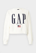 Weißer, kurzer Pullover mit großem, dunkelblauem "GAP"-Schriftzug, darunter "EST. 1969" und einer kleinen Grafik der Betsy Ross amerikanischen Flagge.