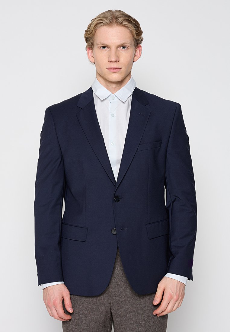 Marineblauer Blazer mit zwei Vordertaschen, zwei Knöpfen und einer glatten Textur, kombiniert mit einem hellblauen Hemd mit Kragen darunter.