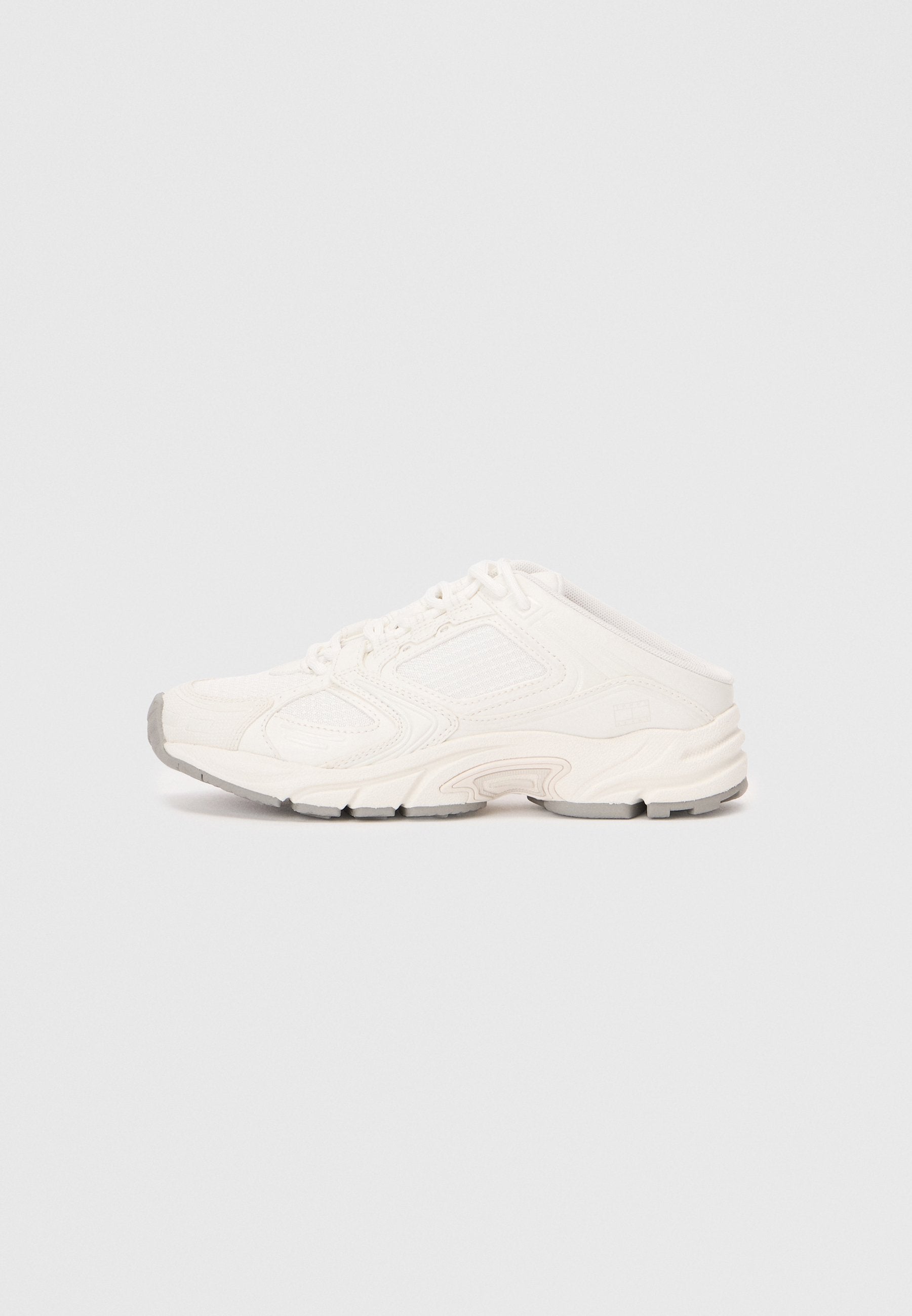 Weißer Sportschuh mit Obermaterial aus Mesh und synthetischem Material, runder Zehenbereich, gekrümmte Sohle und strukturierten Akzenten. Die Schnürsenkel sind unter einer Sport-stil Überlage verborgen.