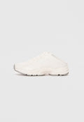 Weißer Sportschuh mit Obermaterial aus Mesh und synthetischem Material, runder Zehenbereich, gekrümmte Sohle und strukturierten Akzenten. Die Schnürsenkel sind unter einer Sport-stil Überlage verborgen.