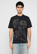Schwarzes Baumwoll-T-Shirt mit einer Linienzeichnung von Blumen in Beige auf der Vorderseite. Kurze Ärmel und runder Ausschnitt. Lässige Passform.