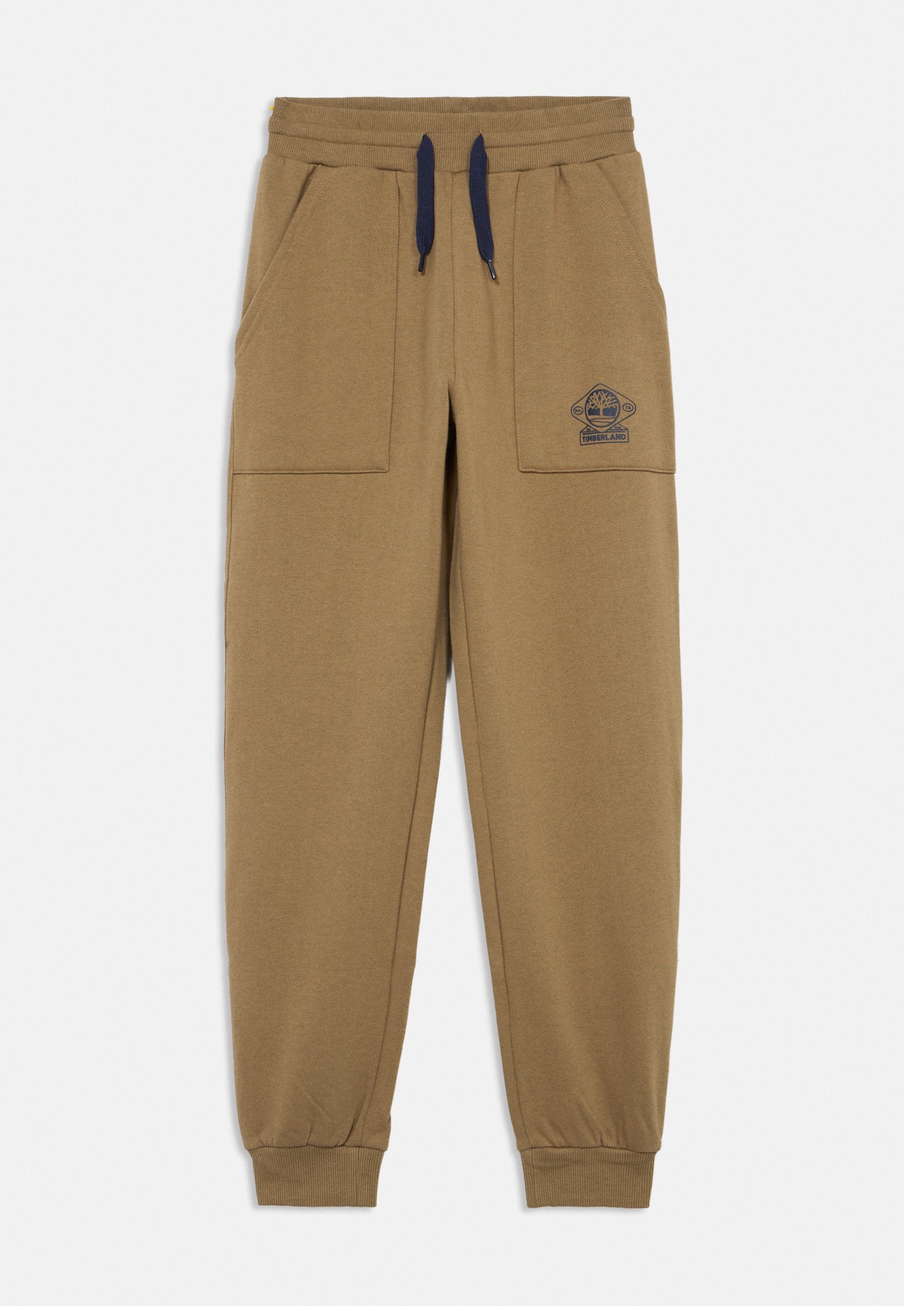 Braune Baumwoll-Jogginghose mit Kordelzugbund, Seitentaschen und gerippten Bündchen. Verziert mit einem kleinen blauen Timberland-Logo am Oberschenkel.