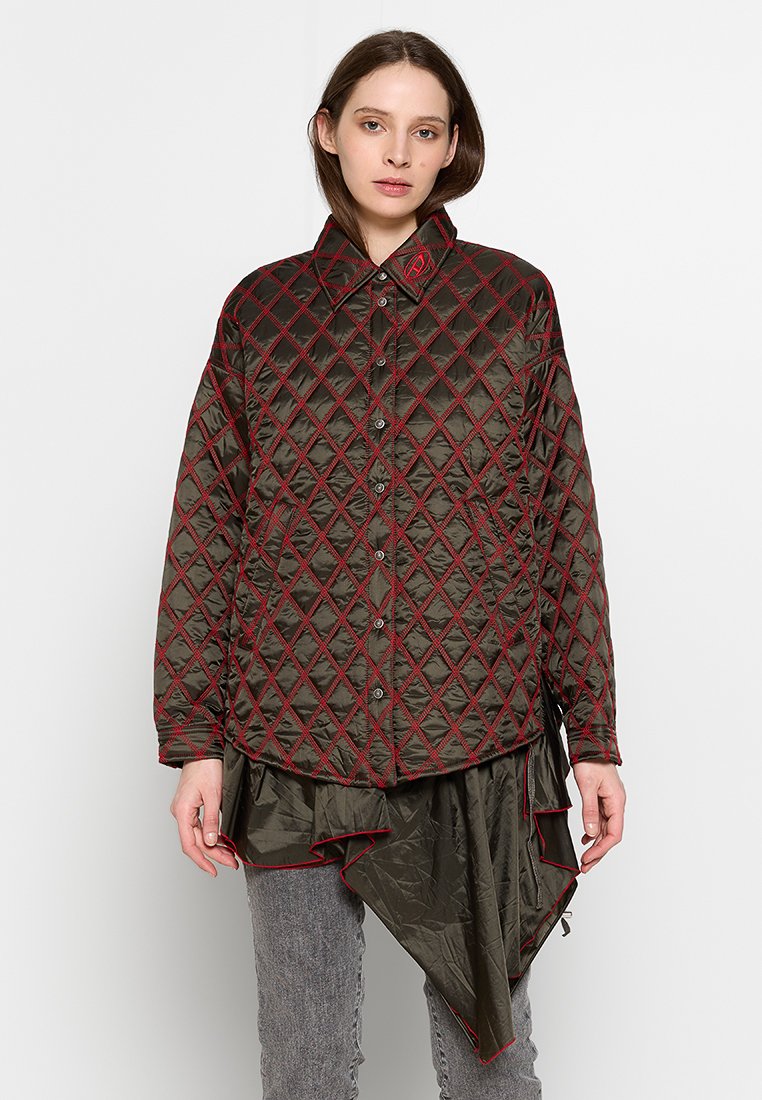 Quilted Jacke in Dunkelgrün mit rotem Rautenmuster, ausgestattet mit einem spitzen Kragen, Knöpfen und einem lockeren, asymmetrischen Saum.