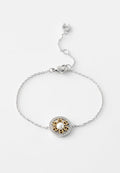 Silberne Kettenarmband mit einem runden Anhänger mit goldenen Akzenten, einer zentralen Perle und einem Rand aus klaren Strasssteinen.