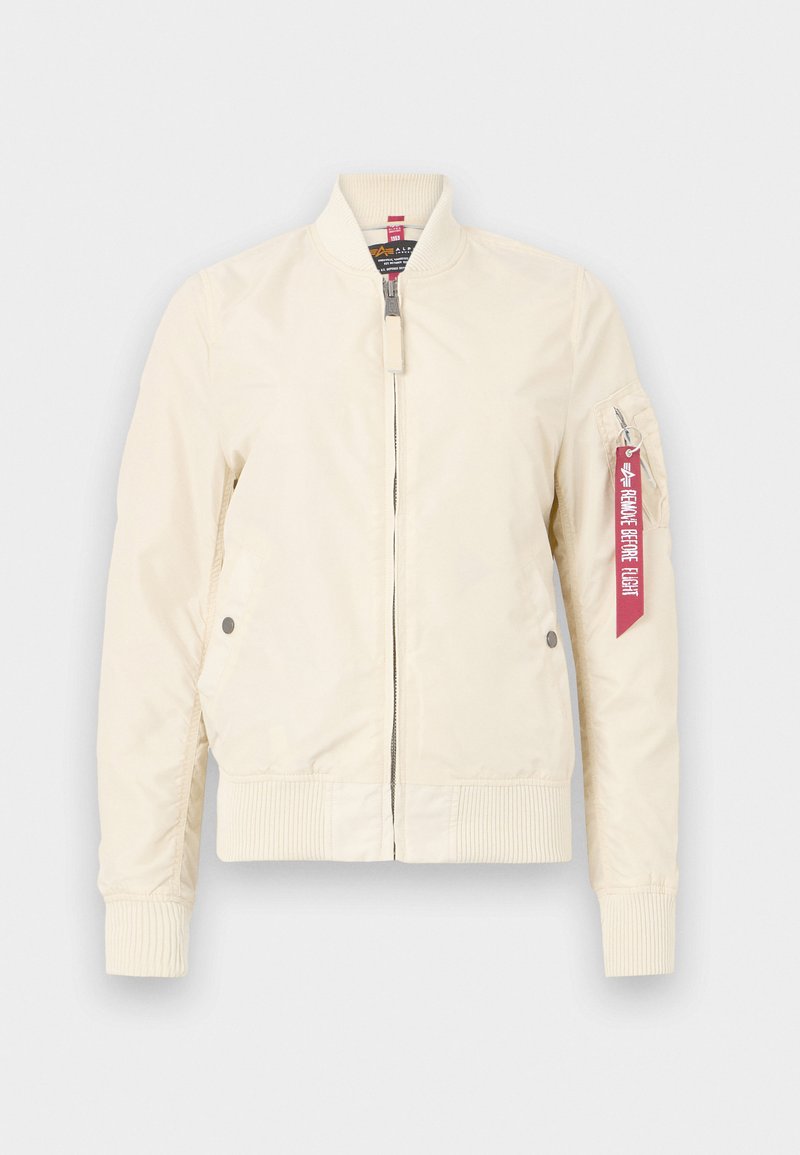 Hellbeige Bomberjacke mit gerippten Bündchen und Saum, Reißverschluss und Seitentaschen. Besitzt ein rotes Etikett am Ärmel. Glatte Textur.