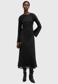Schwarzes, langärmeliges Kleid mit strukturiertem Stoff, tailliertem Oberteil und ausgestellten Ärmeln; kombiniert mit knielangen schwarzen Stiefeln und einer kleinen Tasche.