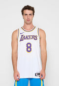 Mann trägt ein weißes Lakers Basketballtrikot mit der Nummer 8 und blaue Shorts und steht vor einem schlichten Hintergrund.