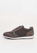 Grauer Freizeitsneaker mit Veloursleder- und Mesh-Elementen, Schnürung vorne, Seitlicher Reißverschluss, weiße Sohle und schwarze Laufsohle, von der Außenseite betrachtet.