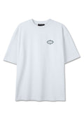 Weißes übergroßes T-Shirt mit kurzen Ärmeln, das ein kleines grünes kreisförmiges Logo und Text auf der linken Brustseite zeigt.