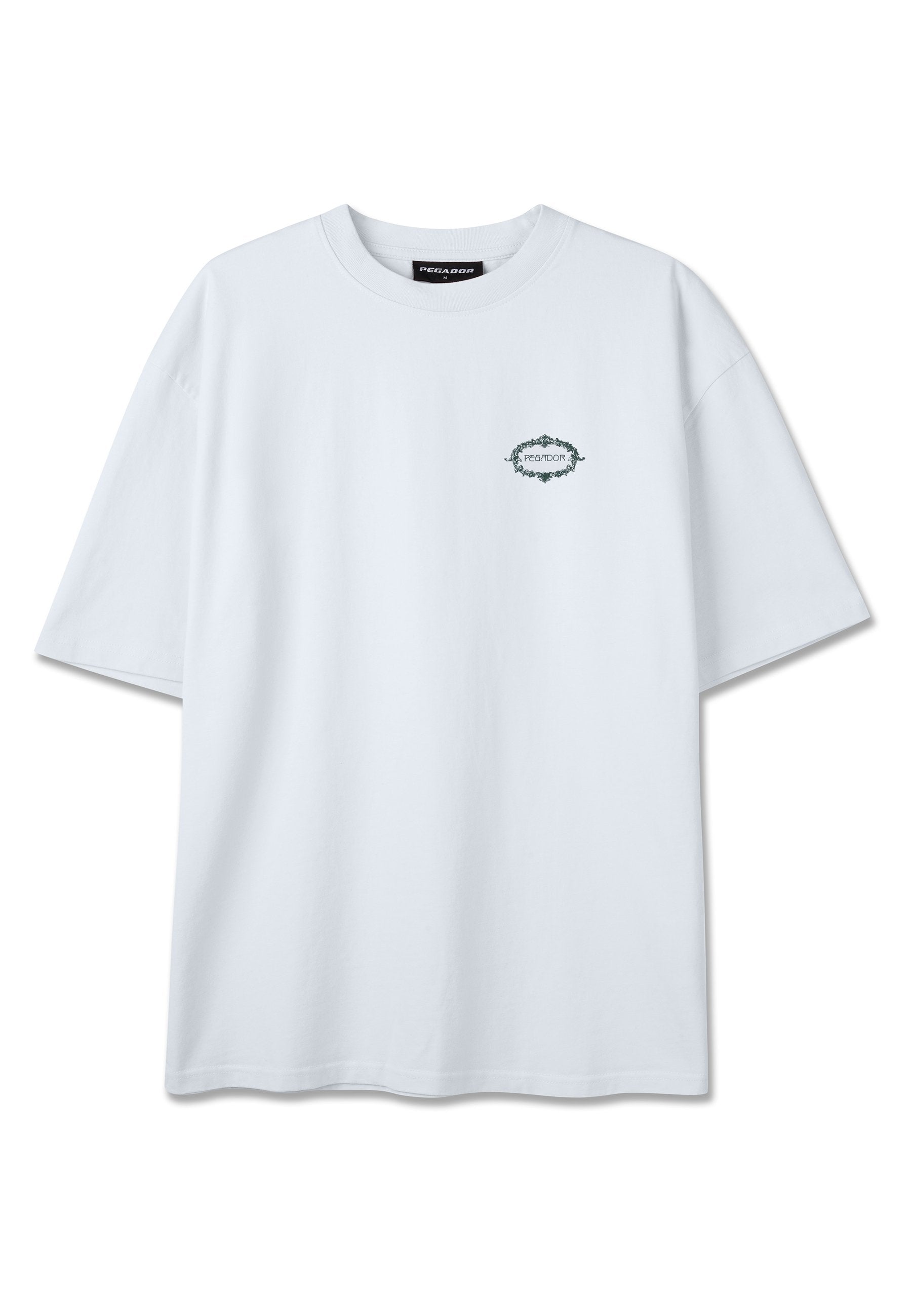 Weißes übergroßes T-Shirt mit kurzen Ärmeln, das ein kleines grünes kreisförmiges Logo und Text auf der linken Brustseite zeigt.