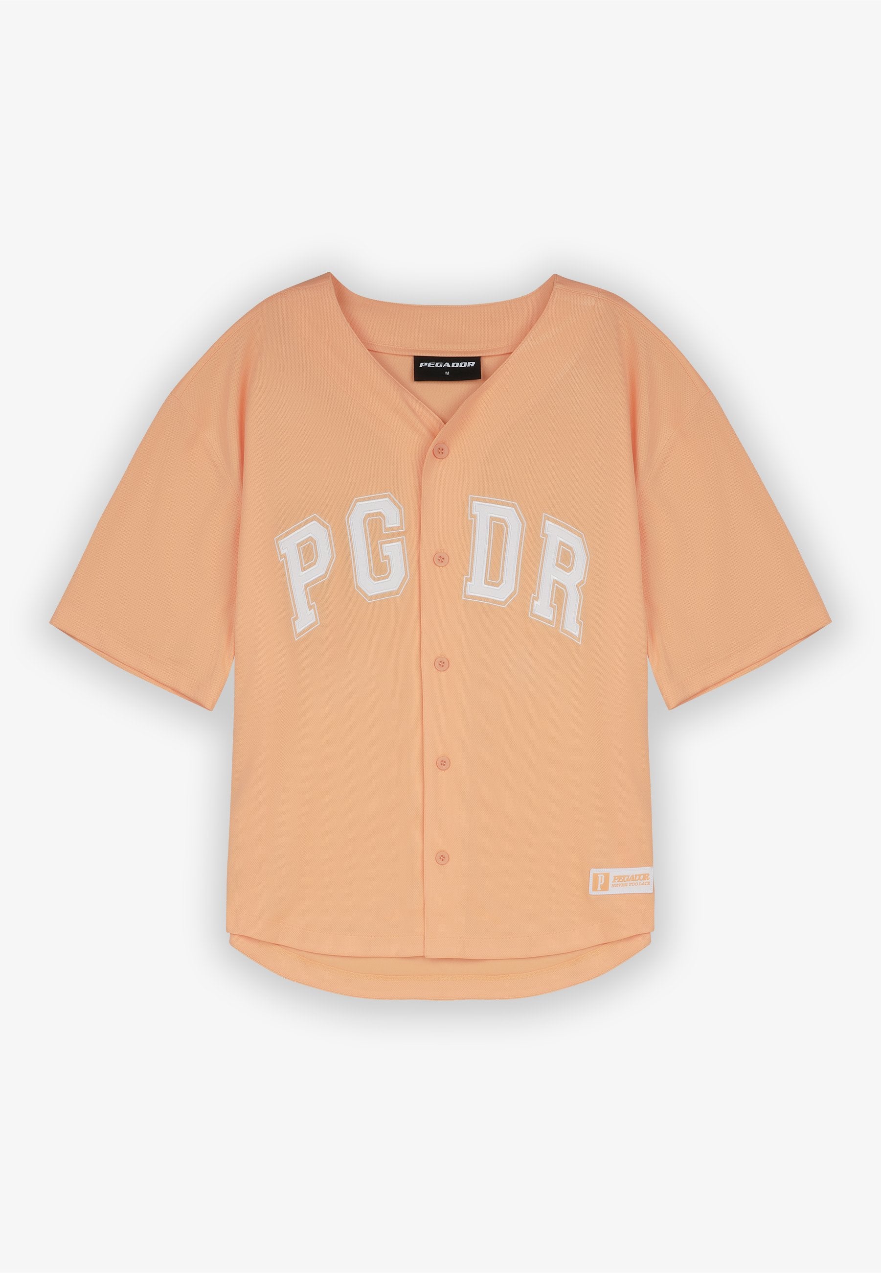 Pfirsichfarbendes Kurzarmshirt aus Jersey mit Knopfleiste und weißem Aufdruck "PG DR." Besitzt einen abgerundeten Saum und einen gerippten Halsausschnitt.