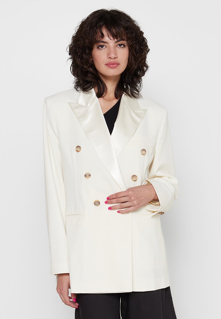 Doppeltknopf-Blazer in Elfenbein mit satinierter Spitzenkragen, goldenen Knöpfen und taillierten Taschen. Glattes Material mit strukturierter Silhouette.