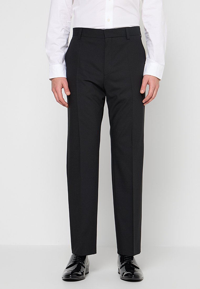 Schwarze Stoffhose mit glattem, vorderseitigem Schnitt aus glattem Material. Verfügt über Gürtelschlaufen und eine leichte Bügelfalte auf der Vorderseite. Maßgeschneiderte Passform.