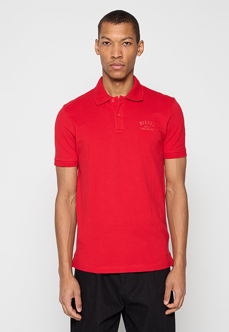 Rotes Poloshirt mit Kragen, kurzen Ärmeln und einem kleinen Logo auf der linken Brust. Aus Baumwolle für eine glatte Textur gefertigt.
