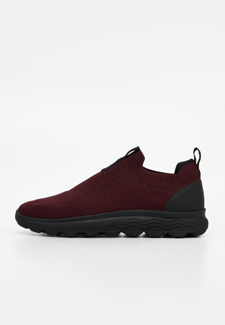Bordeauxfarbiger gestrickter Slip-On-Sneaker mit schwarzer dicker Sohle, Fersenzuglasche und strukturiertem Obermaterial für eine eng anliegende, bequeme Passform.