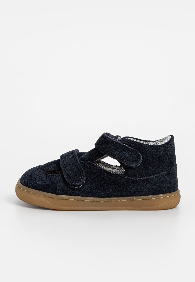 Navyblaue Wildlederschuhe mit Klettverschlüssen, abgerundeter Spitze, atmungsaktiven Ausschnitten und einer flexiblen braunen Gummisohle.
