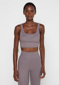 Grauer gerippter Cropped-Top mit breiten Trägern und rundem Ausschnitt, mit einem weißen "DAILY PAPER"-Logo auf der Vorderseite.