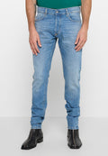 Hellblaue Jeans im Slim-Fit-Schnitt, mit ausgewaschenem Design, fünf Taschen und Knopfverschluss, kombiniert mit schwarzen Knöchelstiefeln.