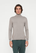 Eng anliegender, hellgrauer Rollkragenpullover aus geripptem Strickstoff. Mit langen Ärmeln und dezentem Logodetail auf der Brust.